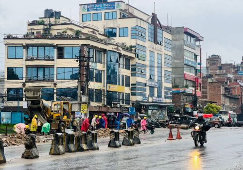 अरनिको राजमार्ग अन्तरगत बनेपा खण्डमा झरिमा पनि काम गर्दै मजदुरहरू ।